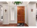 Inviting entryway featuring a solid wood front door, neutral paint, and beautiful wood floors at 5509 E Desert Hills Dr, Scottsdale, AZ 85254