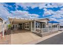 Charming single-story home featuring a covered porch, carport, and nicely landscaped front yard with a seating area at 650 N Hawes Rd # 4128, Mesa, AZ 85207