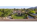 Expansive aerial view of a luxury home with manicured lawns, mature trees, and a circular driveway at 6997 E Paradise Ranch Rd, Paradise Valley, AZ 85253