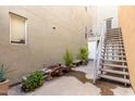 Exterior shot featuring a wooden staircase, potted plants, bench seating, and a textured neutral wall at 706 E Washington St # 207, Phoenix, AZ 85034