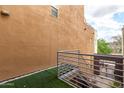 A view from the balcony showing a brown textured wall with artificial grass at 706 E Washington St # 207, Phoenix, AZ 85034