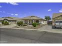 Charming single-story home featuring desert landscaping, tile roof, covered porch, and two-car garage at 7832 E Osage Ave, Mesa, AZ 85212