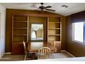 Formal dining room with a built-in bookcase, a stylish ceiling fan, and a large window at 830 E Dry Creek Rd, San Tan Valley, AZ 85143