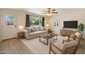 Bright living room with a neutral palette, wood floors, large window, and comfortable seating arrangement at 8725 E Coronado Rd, Scottsdale, AZ 85257