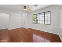 Well-lit living room showcases wood floors, a large window, and a ceiling fan at 8745 W Windsor Dr, Peoria, AZ 85381