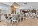 Elegant dining room featuring a contemporary chandelier, a large table, and access to the kitchen and other living areas at 9343 W Atlantis Way, Tolleson, AZ 85353