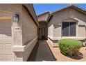 A close-up view of a home's exterior, highlighting its well-manicured entrance and desert landscaping at 16768 W Nottingham Way, Surprise, AZ 85374