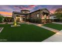 Inviting home exterior at twilight, enhanced with landscape lighting and stone detailing at 20759 W Meadowbrook Ave, Buckeye, AZ 85396