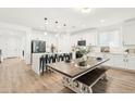 Bright kitchen features white cabinets, a central island with seating, and a wood dining table at 3828 S 180Th Ln, Goodyear, AZ 85338