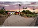Beautiful sunset view of the well-manicured front yard, circular driveway, and bright bougainvillea at 10380 E Cholla St, Scottsdale, AZ 85260