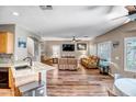 Spacious living room with hardwood floors, a ceiling fan, and ample natural light from the large windows at 14246 W Columbus Ave, Goodyear, AZ 85395