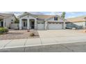 Charming single-story home featuring a three-car garage, tiled roof, and desert landscaping at 1584 E Harrison E St, Chandler, AZ 85225