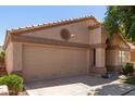Single-story home featuring a desert landscape, a round window accent and a two-car garage at 17119 N Joshua Path, Surprise, AZ 85374