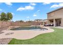 Resort-style backyard featuring a large pool, water feature, and lush landscaping for outdoor enjoyment at 1754 E Bradstock Way, San Tan Valley, AZ 85140