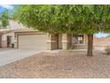 Charming two-story home with a two-car garage, drought-tolerant landscaping, and a mature shade tree at 1754 E Bradstock Way, San Tan Valley, AZ 85140
