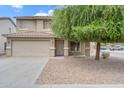 Inviting two-story home featuring a classic facade, two-car garage, and drought-tolerant landscaping at 1754 E Bradstock Way, San Tan Valley, AZ 85140