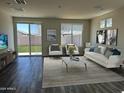 Bright living room with modern decor, large windows, and access to a fenced backyard at 17983 W Sand Hills Rd, Surprise, AZ 85387