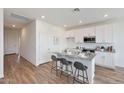 Bright kitchen with white cabinets, granite counters, stainless steel appliances and breakfast bar at 18009 W Sand Hills Rd, Surprise, AZ 85387