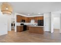 Open kitchen with black appliances, wood cabinets, and an island with a white countertop at 238 W Kona Dr, Casa Grande, AZ 85122