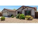 A single-story home exhibits a well-maintained yard with desert landscaping and a light neutral color palette at 30 S 230Th Ave, Buckeye, AZ 85326