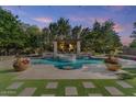 Beautiful pool area with a spa, a pergola with a fireplace, and lush landscaping at 3011 E Morrison Ranch Pkwy, Gilbert, AZ 85296