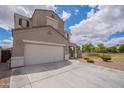View of the home's exterior featuring a two-car garage and neutral stucco against a blue sky at 4205 W Maggie Dr, San Tan Valley, AZ 85144