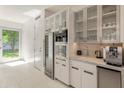 Kitchen with white cabinetry, stainless steel appliances, a built in sink, wine fridge, and door to the yard at 523 W Vista Ave, Phoenix, AZ 85021