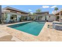 Luxury backyard pool with tanning ledge surrounded by travertine decking, chaise lounges, and lush landscaping at 523 W Vista Ave, Phoenix, AZ 85021
