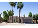 Attractive single-story home with palm trees, desert landscaping, and a convenient two-car garage at 6721 E Phelps Rd, Scottsdale, AZ 85254