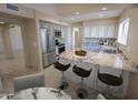 Bright kitchen featuring white cabinetry, stainless steel appliances, and granite countertops with bar seating at 6721 E Phelps Rd, Scottsdale, AZ 85254