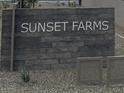 Elegant community sign for Sunset Farms, set against a textured stone background at 9539 W Parkway Dr, Tolleson, AZ 85353