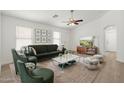 Bright living room with modern furniture, a ceiling fan, and ample natural light at 9740 E Baltimore Cir, Mesa, AZ 85207