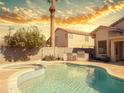 Backyard pool features a jacuzzi, BBQ, and lush landscaping, perfect for relaxing and entertaining at 1342 N Mckenna Ln, Gilbert, AZ 85233