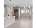 Open kitchen area featuring white cabinets, quartz countertops, tile backsplash, and a modern chandelier at 22762 E Stacey Rd, Queen Creek, AZ 85142