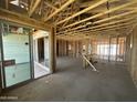 Unfinished home interior showcasing exposed framing, concrete floors, and sliding glass doors at 2328 E Spur Dr, San Tan Valley, AZ 85140