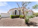 Charming single-story home featuring mature landscaping with gravel, an American flag, and an arched window at 2821 E Pontiac Dr, Phoenix, AZ 85050