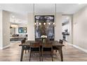 Dining area featuring modern light fixture, art, and wood-look flooring at 10478 E Sheena Dr, Scottsdale, AZ 85255