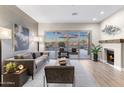 Comfortable living room with a fireplace, a sliding glass door to backyard and a contemporary design at 10478 E Sheena Dr, Scottsdale, AZ 85255