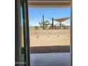 View from home of shaded playground, safety fence, and desert landscaping at 10612 W Sonrisas St, Tolleson, AZ 85353