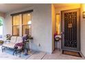 Inviting front porch with cozy seating, decorative plants, and a security door for added curb appeal at 12300 N 142Nd Ln, Surprise, AZ 85379