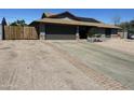 Exterior view of a charming home with a wide driveway, garage, and desert landscaping at 1316 N Spring Cir, Mesa, AZ 85203