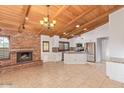 Open kitchen and living space featuring stainless appliances and a charming brick fireplace at 1316 N Spring Cir, Mesa, AZ 85203