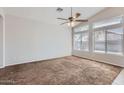 Bright living room with neutral carpet, a ceiling fan, and plenty of natural light at 13337 W Evans Dr, Surprise, AZ 85379