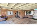 Cozy covered porch with a brick facade, decorative touches, and comfortable seating area at 1520 W Encanto Blvd, Phoenix, AZ 85007
