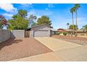 Attractive exterior view featuring desert landscaping, a two-car garage, palm trees, and block wall in a residential neighborhood at 16412 N 33Rd Ave, Phoenix, AZ 85053