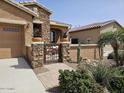 Exterior shot featuring a decorative wrought iron courtyard gate and desert landscaping at 16781 S 181St Ln, Goodyear, AZ 85338
