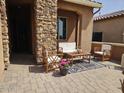 Covered front porch featuring an outdoor seating area with a brick paver floor at 16781 S 181St Ln, Goodyear, AZ 85338
