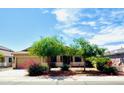 Charming home boasts desert landscaping, a three-car garage, and mature trees at 17840 N Smith Dr, Maricopa, AZ 85139