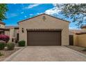 Home exterior featuring a paved driveway leading to a two-car garage with desert landscaping at 1813 N Trowbridge --, Mesa, AZ 85207