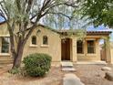 Inviting single-story home featuring a cozy porch and mature tree at 1867 S Seton Ave, Gilbert, AZ 85295